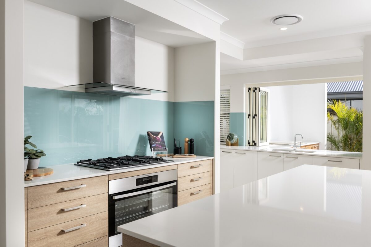 an aqua blue splashback in the kitchen adds a bold pop of colour